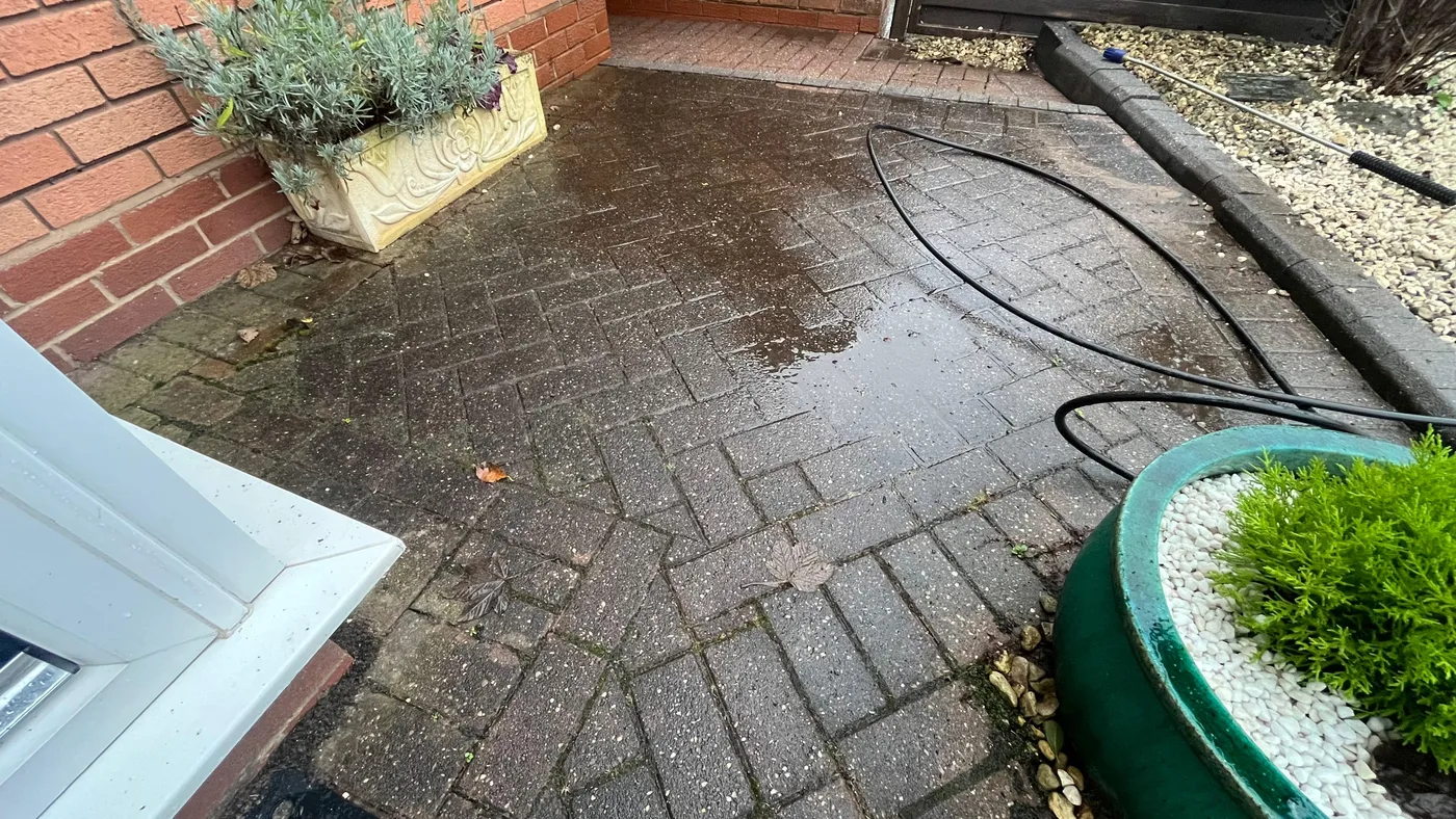 Dirty block paved entryway patio before jet washing